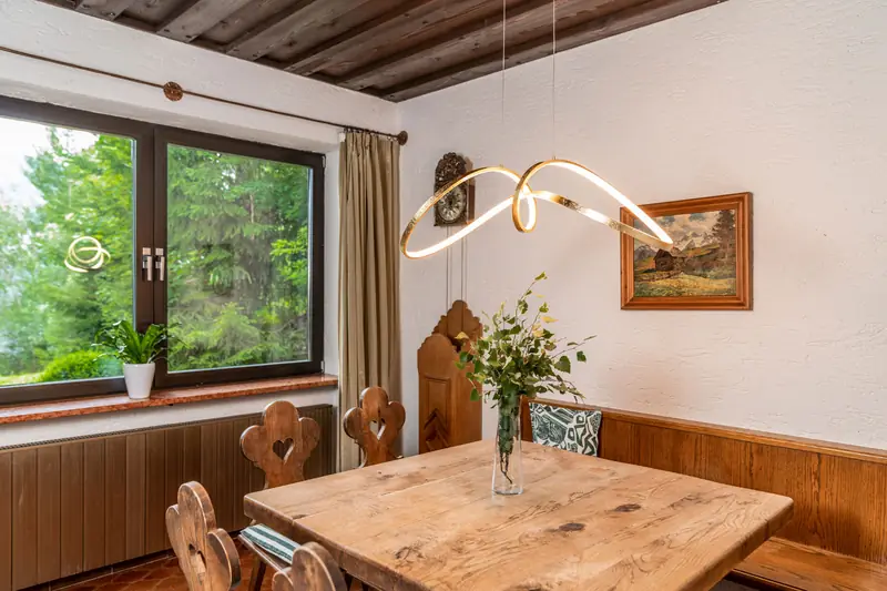 Massiver Holztisch mit Blumen am Fenster
