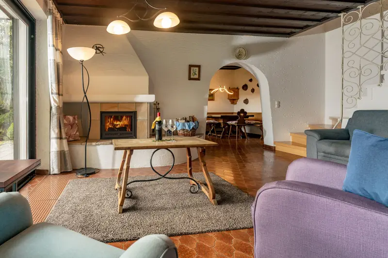 Wohnzimmer mit Couchtisch, Kamin und Durchgang zur Stube
