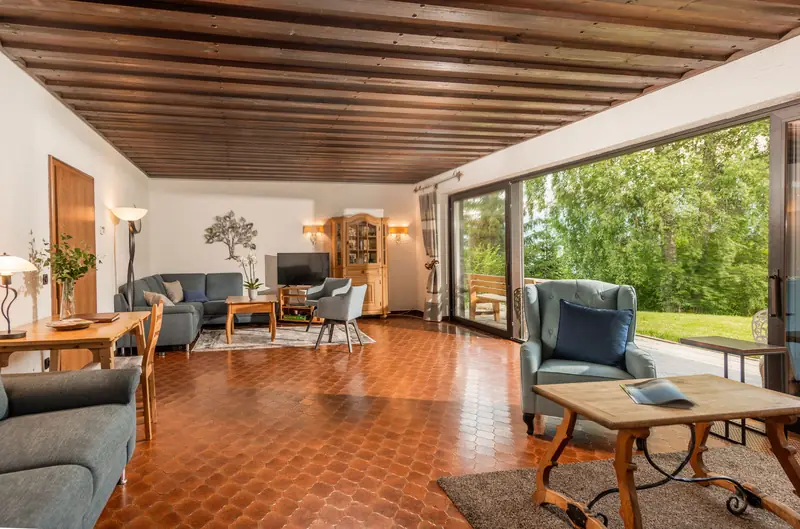 Großes helles Wohnzimmer mit Sofaecke und Fensterfront